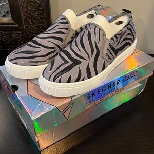 Brand new, never worn. Skechers street zebra slip on shoes